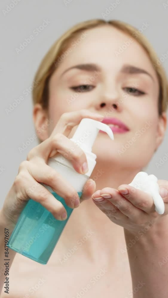 Vertical video. Portrait of a young woman using a cosmetic cleansing foam. A pretty blonde with an attractive appearance. Skin care spa relaxation concept. Vertical video. Portrait of a young woman using a cosmetic cleansing foam. A pretty blonde with an attractive appearance. Skin care spa relaxation concept.