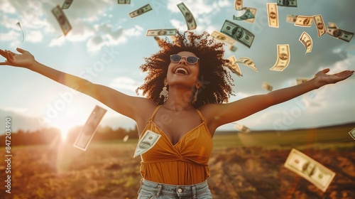 Joyful woman celebrating with falling money outdoors