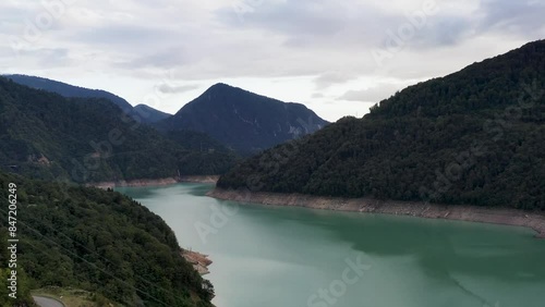 Aerial view of the turquoise reservoir. Beautiful view of the road among the mountains.  View of the river, road, clouds. 4k video. 