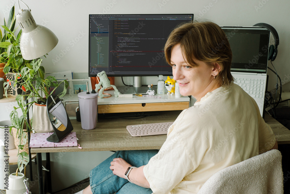 Female programmer pensively looking out from her workplace Female programmer pensively looking out from her workplace