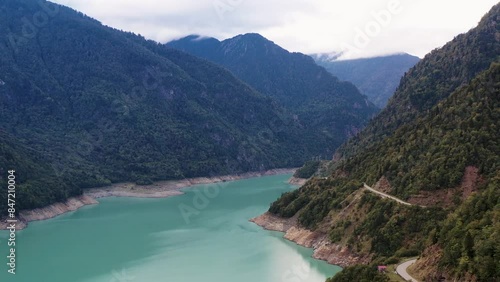 Aerial view of the turquoise reservoir. Beautiful view of the road among the mountains.  View of the river, road, clouds. 4k video. 