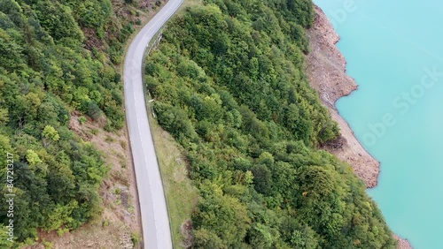 Aerial view of the turquoise reservoir. Beautiful view of the road among the mountains.  View of the river, road, clouds. 4k video. 