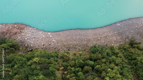 Aerial view of the turquoise reservoir. Beautiful view of the road among the mountains.  View of the river, road, clouds. 4k video. 