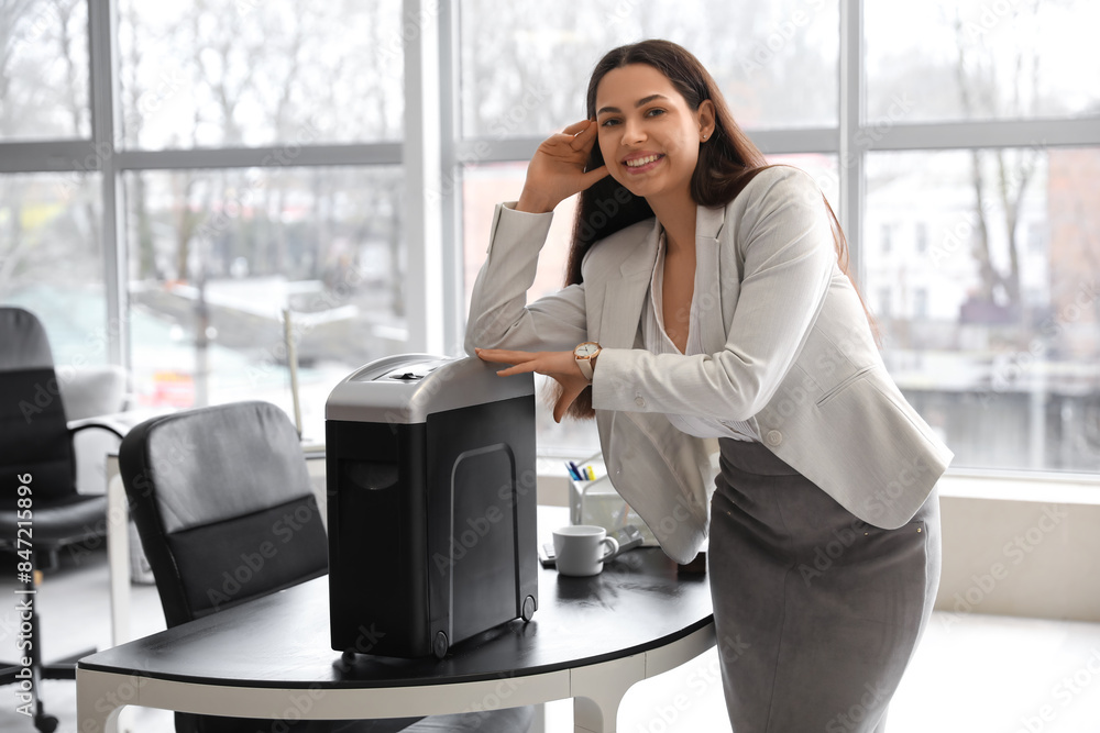 Young secretary with shredder in office Young secretary with shredder in office