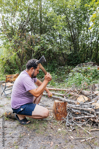 Man Chopping Wood in Forest photo