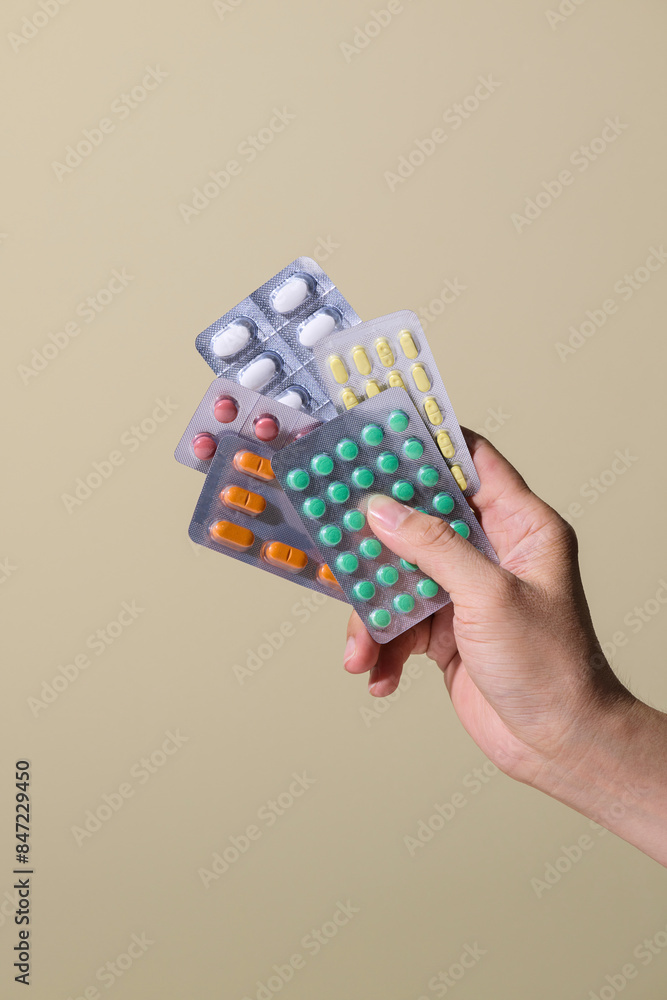 Girl holds pills in hands on a yellow background Girl holds pills in hands on a yellow background