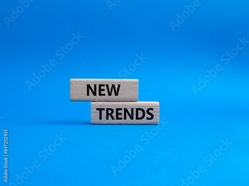 New Trends symbol. Wooden blocks with words New Trends. Beautiful blue background. Business and New Trends concept. Copy space.