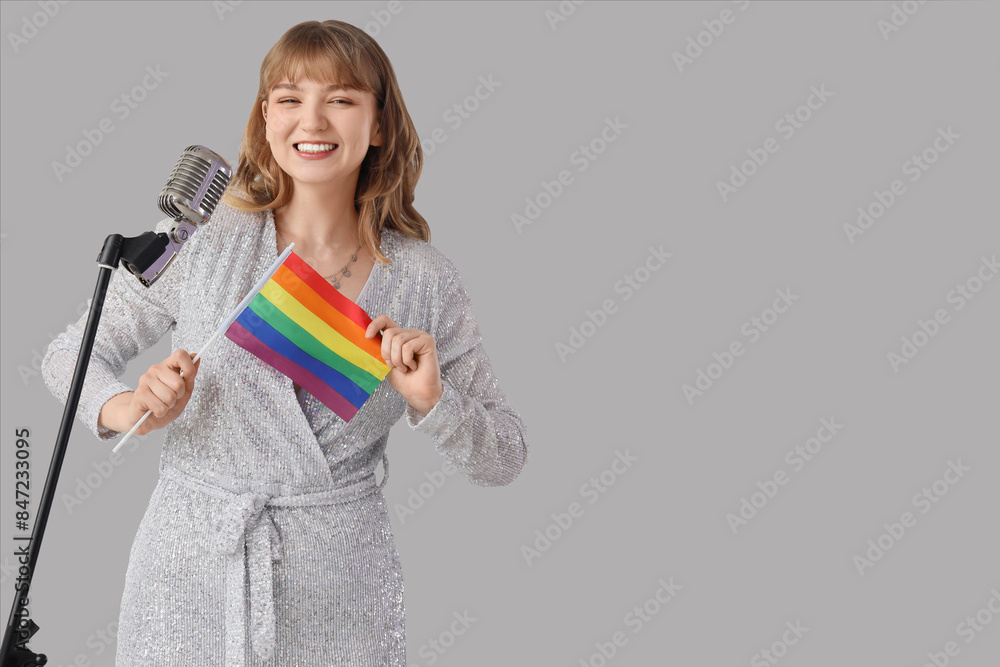 Female singer with LGBT flag and microphone on light background