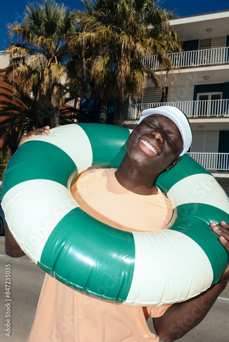 Cheerful man with inflatable ring on street at summer ugc photo