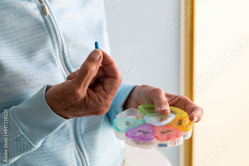 Woman hand  holding prescription pill organizer  photo