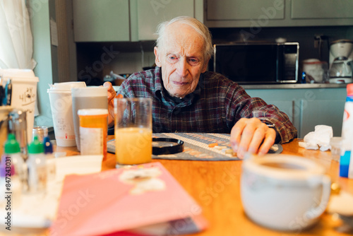 senior citizen taking medication and vitamins in the morning  photo