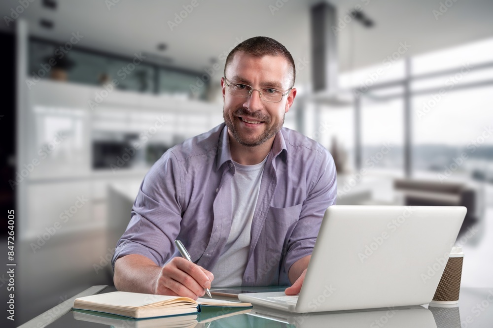 Smiling young man using laptop computer Smiling young man using laptop computer