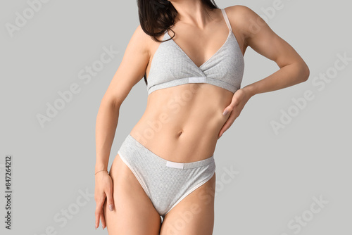 Young woman in underwear on light background © Pixel-Shot