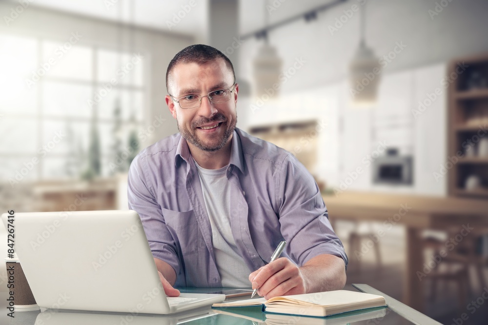 Smiling young man using laptop computer Smiling young man using laptop computer