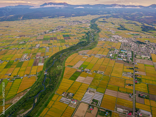 After taking off from Asahikawa Airport in Hokkaido, Japan, an aerial view reveals Higashikagura Town to the east (in the middle right) and the Chubetsu River (in the center).
