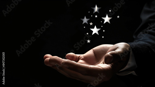 Businessman holds a cluster of gleaming stars in his hand
