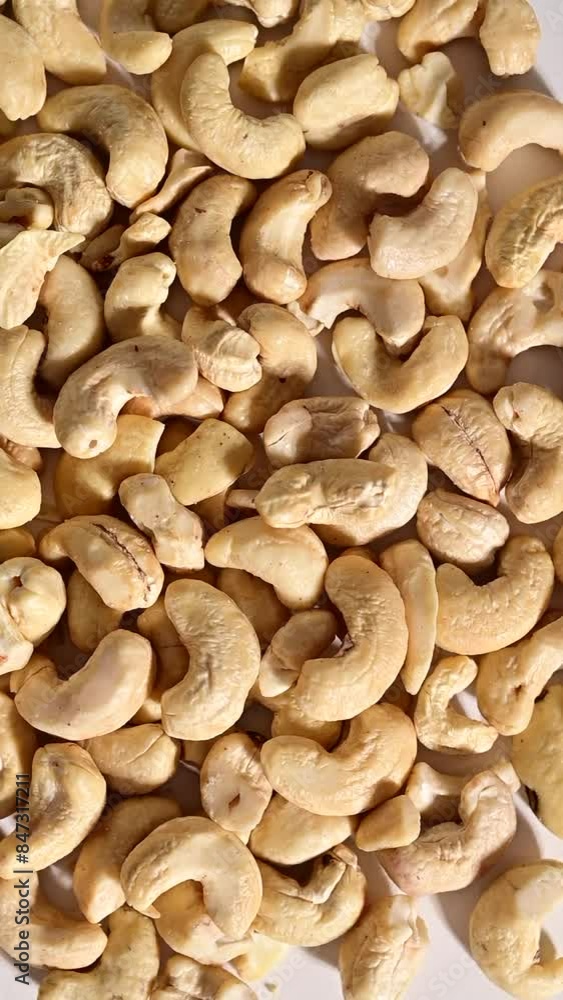 Heap of cashew nuts spinning on a white background. Vertical video. Heap of cashew nuts spinning on a white background. Vertical video.