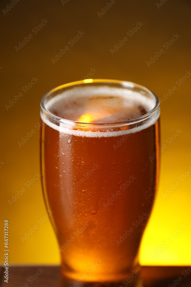 Glass with fresh beer on table against dark background, closeup Glass with fresh beer on table against dark background, closeup
