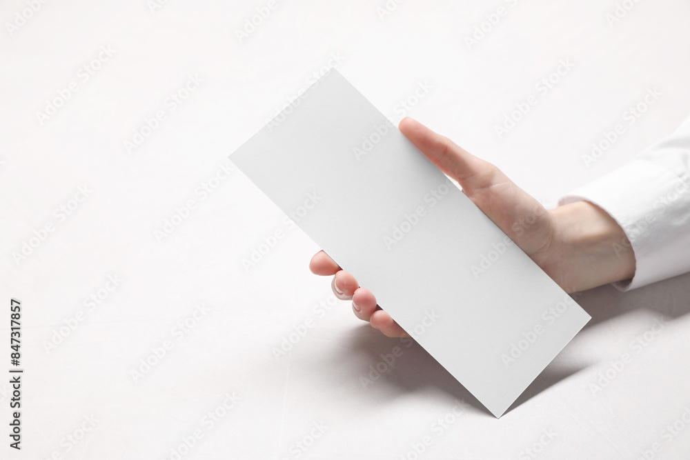 Woman holding blank card at white table, closeup. Mockup for design Woman holding blank card at white table, closeup. Mockup for design
