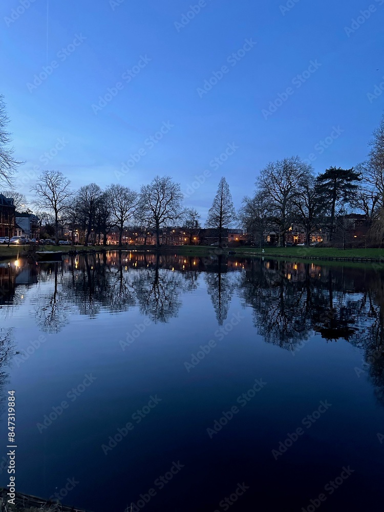 Fototapeta premium Scenic view of river and buildings on shore in evening