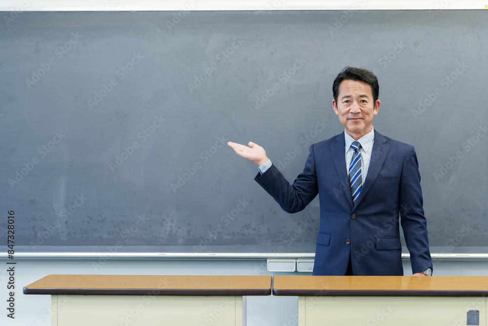 黒板を指し示す教師