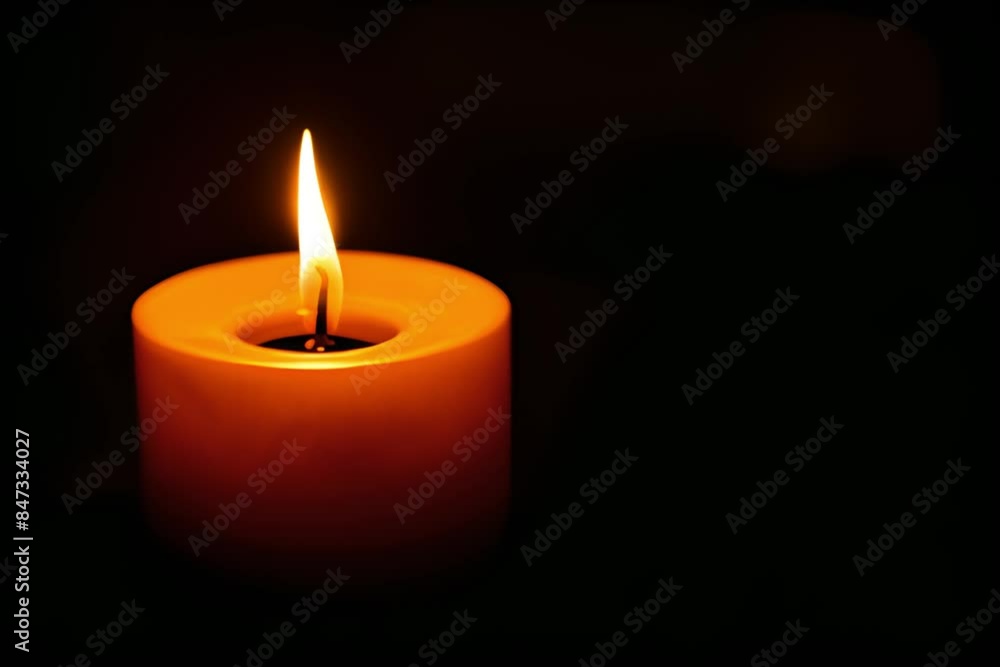 close-up single flame of a burning candle on a black or dark background with copy space. Concept of mourning, memory and sorrow. close-up single flame of a burning candle on a black or dark background with copy space. Concept of mourning, memory and sorrow.