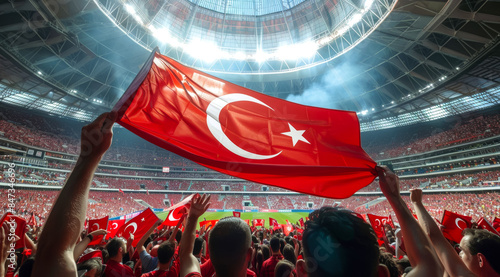 A crowd of people are holding up a red flag with a star on it, football fans at the championship or cup