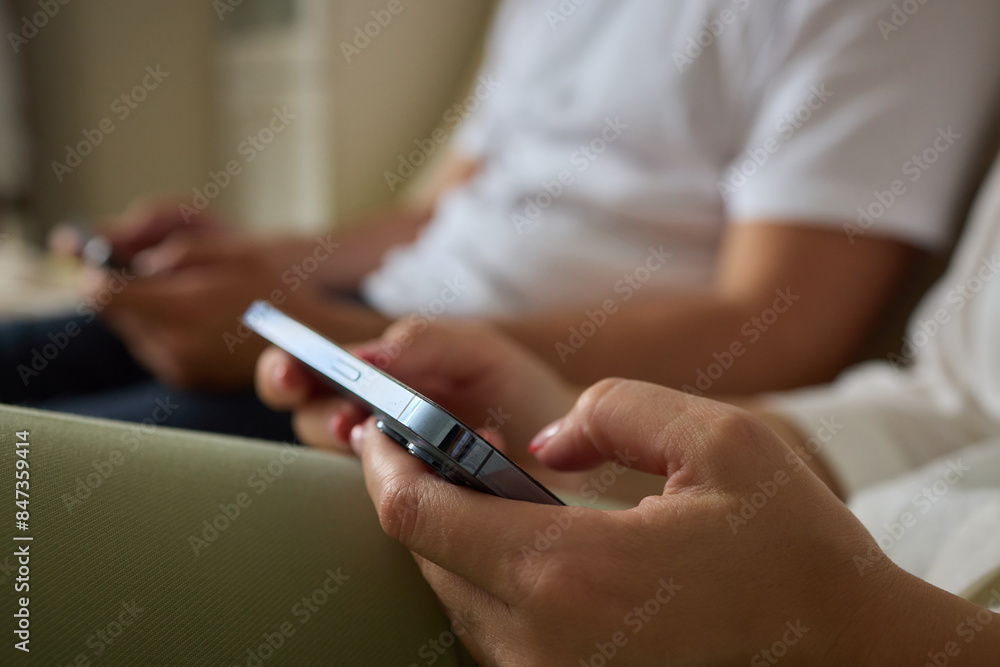 Close-up of a man hands using a phone, He plays a game using mobile internet. Turns the phone vertically. Red light in the evening room Close-up of a man hands using a phone, He plays a game using mobile internet. Turns the phone vertically. Red light in the evening room