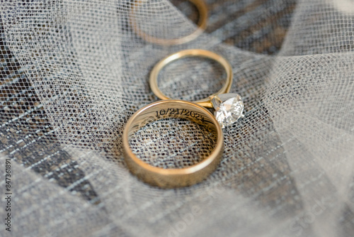 Obraz na plátně Close-up of wedding rings with a date engraving on a veil