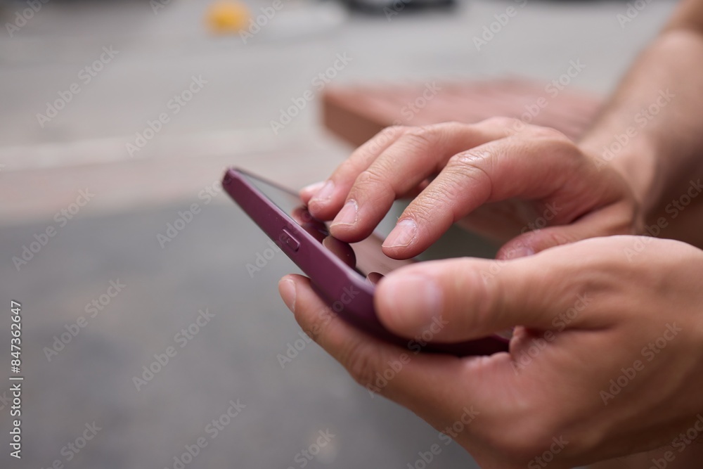 Close-up of a man hands using a phone, He plays a game using mobile internet. Turns the phone vertically. Red light in the evening room Close-up of a man hands using a phone, He plays a game using mobile internet. Turns the phone vertically. Red light in the evening room