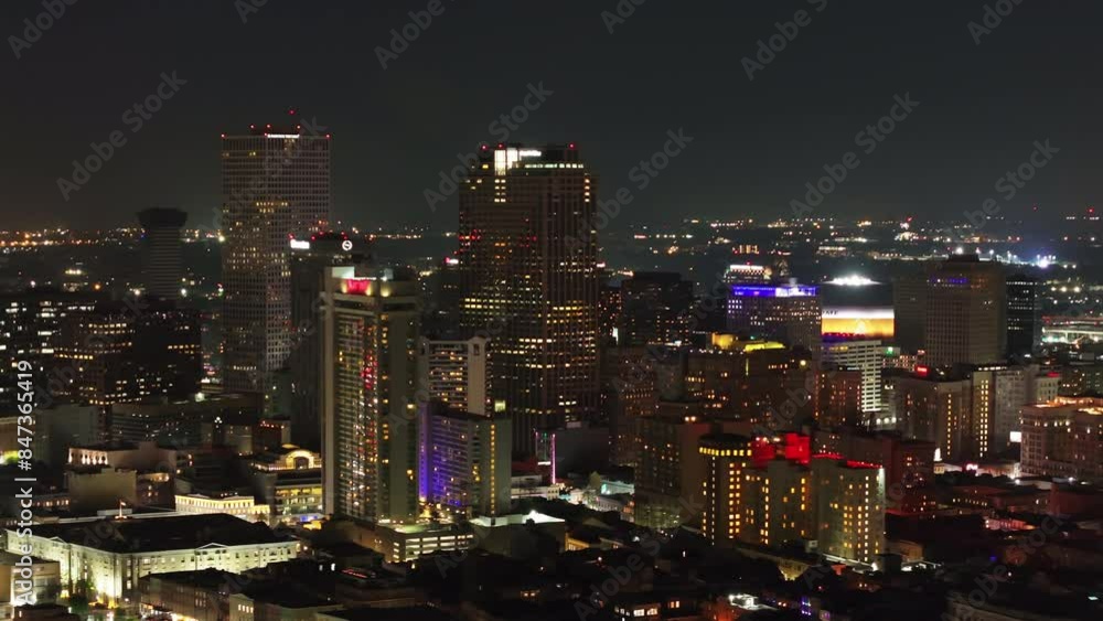 Vibrant lights and skyscrapers of the New Orleans skyline at night in this stunning aerial view, showcasing the city's urban landscape Vibrant lights and skyscrapers of the New Orleans skyline at night in this stunning aerial view, showcasing the city's urban landscape