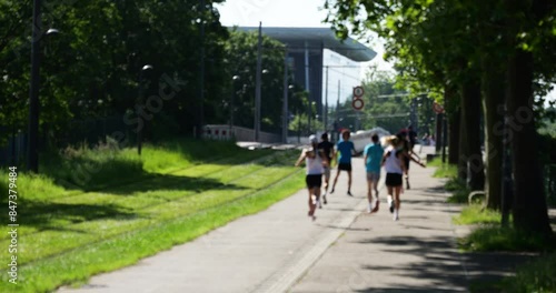 Wallpaper Mural Urban scene of a group of runners with a building in the background, captured during a morning fitness run, highlighting a healthy and active lifestyle Torontodigital.ca