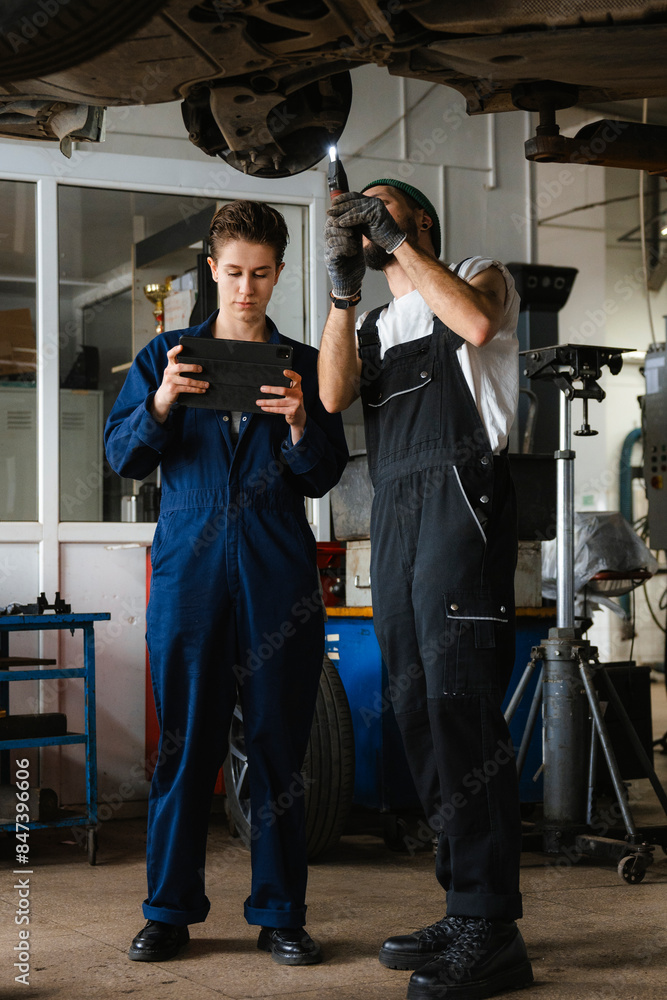 A group of people working in an auto repair shop A group of people working in an auto repair shop