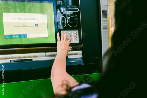 young woman getting cash at drive through ATM photo