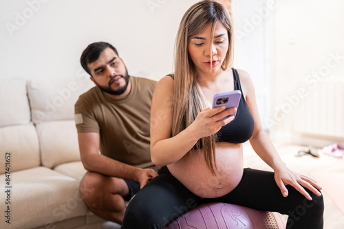 Pregnant couple exercising at home. photo