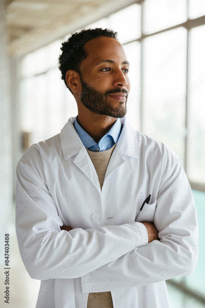Cheerful male doctor in uniform standing near window Cheerful male doctor in uniform standing near window