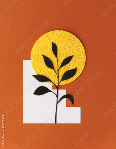 Handmade paper plant with felt sun on orange background
