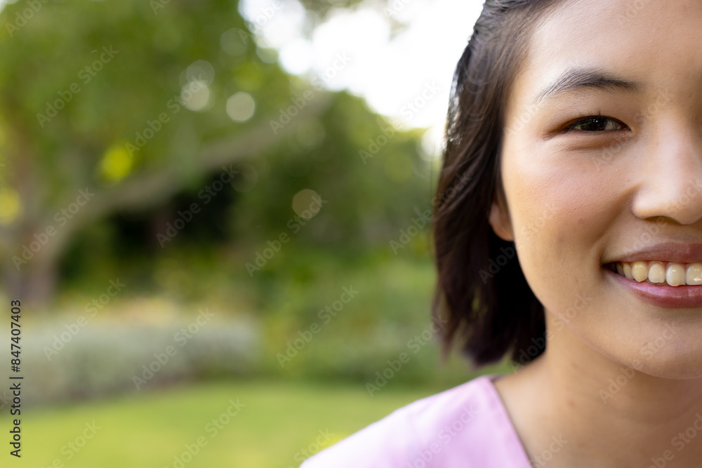 Asian nurse healthcare worker smiling outdoors in lush garden with trees, at home Asian nurse healthcare worker smiling outdoors in lush garden with trees, at home