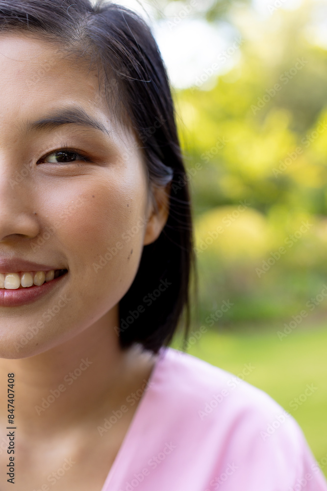 Young Asian woman smiling warmly, outside in garden, at home Young Asian woman smiling warmly, outside in garden, at home