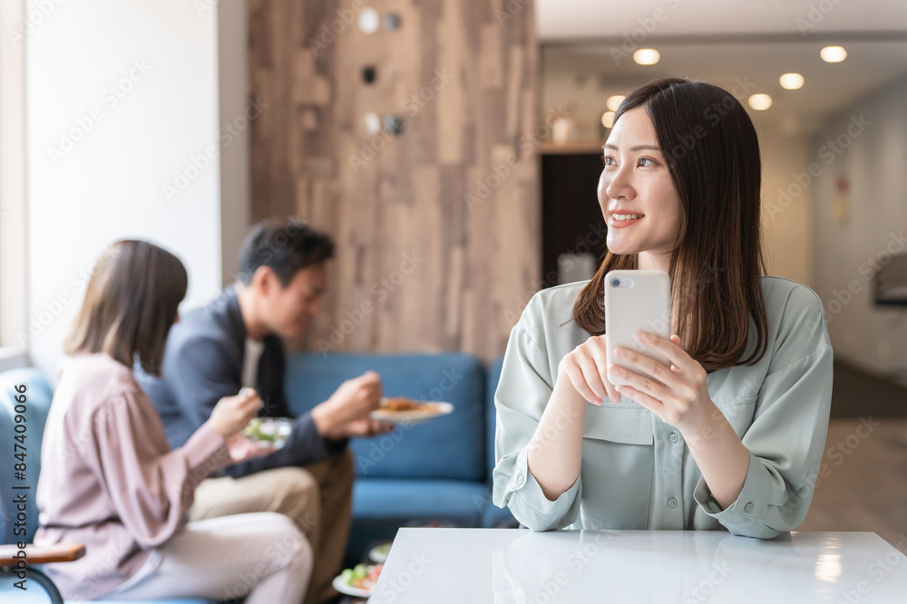 カフェでスマホを使う若いアジア人女性・ビジネスウーマン・大学生
