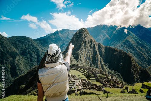 persona con gorro de machipichu señalando la ciudad perdida
