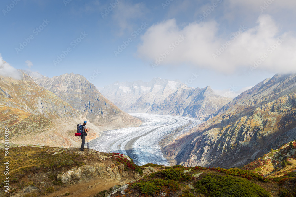Automnal landscape view of a hiker contemplating the Aletsch glacier Automnal landscape view of a hiker contemplating the Aletsch glacier