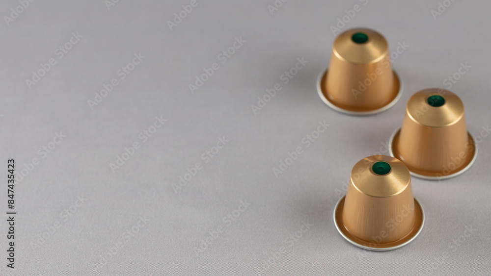 gold coffee capsules arranged on a neutral background, modern design. Advertising. Copy space gold coffee capsules arranged on a neutral background, modern design. Advertising. Copy space