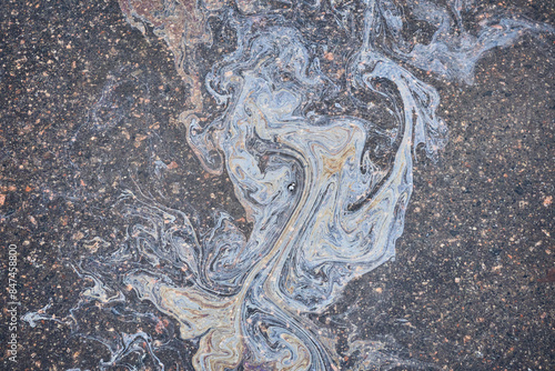 Colored oil stains close-up, color of a gasoline stain on asphalt as a texture or background.
