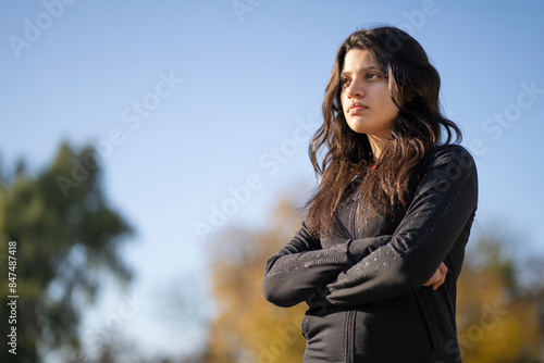 Bilde på lerret Teenage girl with serious expression and arms crossed in the park