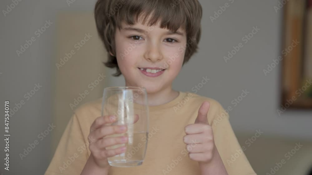 Child Boy Holding Glass Drinking Tasty Clean Pure Mineral Water Showing Thumbs Up Looking at Camera. Person Drinking Water Healthy Body Care. Healthy Lifestyle Children. Pure Filtered Water at Home. Child Boy Holding Glass Drinking Tasty Clean Pure Mineral Water Showing Thumbs Up Looking at Camera. Person Drinking Water Healthy Body Care. Healthy Lifestyle Children. Pure Filtered Water at Home.