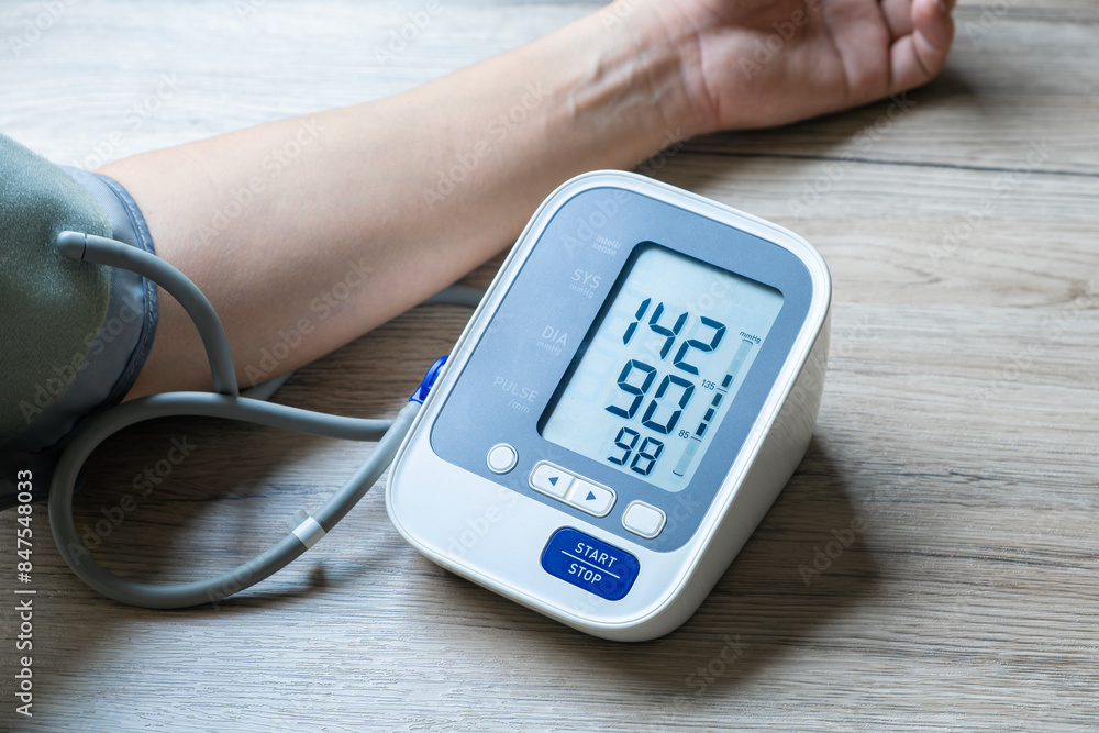 Man check blood pressure monitor and heart rate monitor with digital pressure gauge. Health care and Medical concept Man check blood pressure monitor and heart rate monitor with digital pressure gauge. Health care and Medical concept