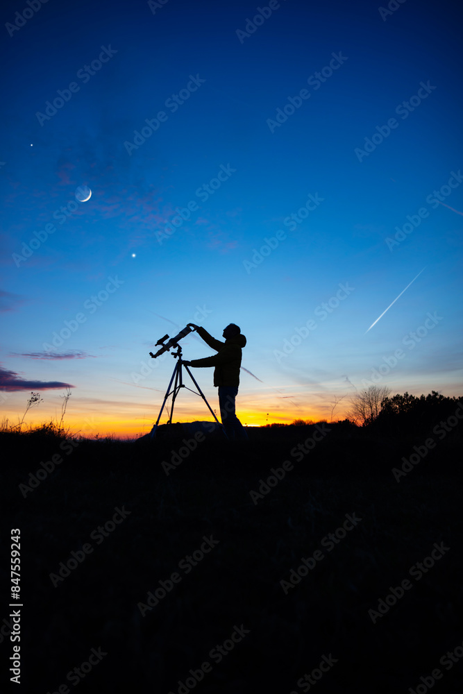 Amateur astronomer looking at the evening skies, observing planets, stars, Moon and other celestial objects with a telescope. Amateur astronomer looking at the evening skies, observing planets, stars, Moon and other celestial objects with a telescope.