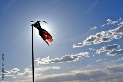 Winds tear American flag and folds it onto a woman’s dress. A metaphor for “Headwinds make you stronger”, “Women’s Rights” and fight for equal rights  photo