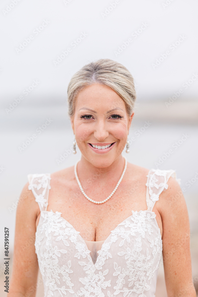 Smiling bride in white lace wedding dress with pearl necklace. Smiling bride in white lace wedding dress with pearl necklace.